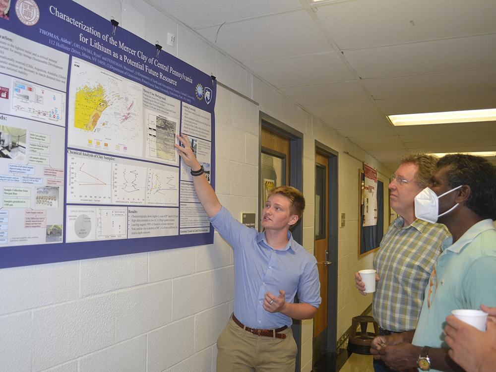 Aiden Thomas, REU participant, explains his research to Andrew Nyblade, head and professor of geosciences,